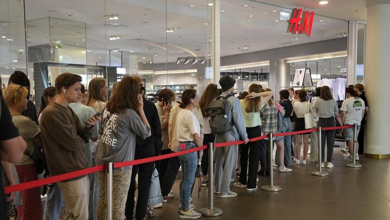 Orang-orang mengantri di luar toko pakaian H&M, yang membuka penjualan terakhir sebelum menutup operasi bisnisnya di Rusia, di pusat perbelanjaan Metropolis di Moskow, Rabu (3/8/2022). Perusahaan Swedia H&M mengumumkan penjualan sisa-sisa barang sebelum penutupan akhir di Rusia. (Photo by NATALIA KOLESNIKOVA/AFP via Getty Images)