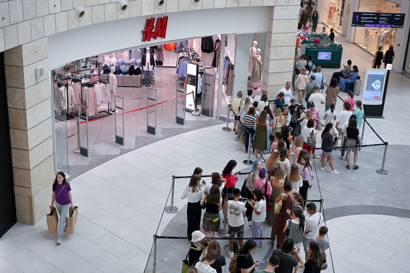 Orang-orang mengantri di luar toko pakaian H&M, yang membuka penjualan terakhir sebelum menutup operasi bisnisnya di Rusia, di pusat perbelanjaan Metropolis di Moskow, Rabu (3/8/2022). Perusahaan Swedia H&M mengumumkan penjualan sisa-sisa barang sebelum penutupan akhir di Rusia. (Photo by NATALIA KOLESNIKOVA/AFP via Getty Images)