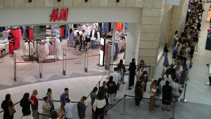 Orang-orang mengantri di luar toko pakaian H&M, yang membuka penjualan terakhir sebelum menutup operasi bisnisnya di Rusia, di pusat perbelanjaan Metropolis di Moskow, Rabu (3/8/2022). Perusahaan Swedia H&M mengumumkan penjualan sisa-sisa barang sebelum penutupan akhir di Rusia. (Photo by NATALIA KOLESNIKOVA/AFP via Getty Images)