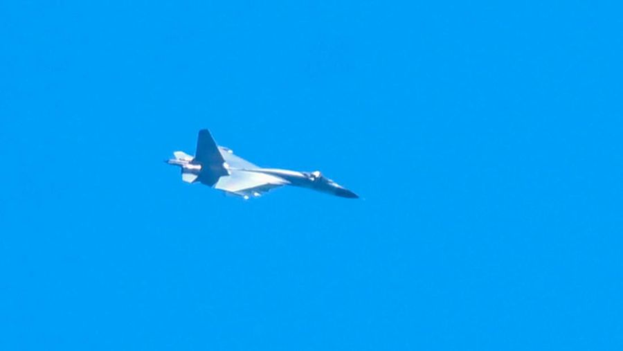 Sebuah jet militer China terbang di atas pulau Pingtan, salah satu titik terdekat daratan China dari Taiwan, di provinsi Fujian, Jumat (5/8/2022). China telah memulai latihan militer di dekat wilayah Taiwan sejak Kamis (4/8). Dalam latihan itu, China mengerahkan rudal balistik, jet tempur, dan kapal perang di sekitar Taiwan. (Photo by HECTOR RETAMAL/AFP via Getty Images)