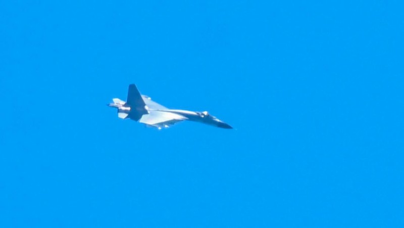 Sebuah jet militer China terbang di atas pulau Pingtan, salah satu titik terdekat daratan China dari Taiwan, di provinsi Fujian, Jumat (5/8/2022). China telah memulai latihan militer di dekat wilayah Taiwan sejak Kamis (4/8). Dalam latihan itu, China mengerahkan rudal balistik, jet tempur, dan kapal perang di sekitar Taiwan. (Photo by HECTOR RETAMAL/AFP via Getty Images)