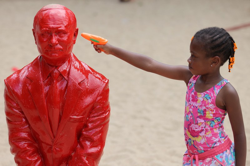 UKRAINE-CRISIS/USA-STATUE Children put sand on a statue of Russian President Vladimir Putin riding a tank created by French artist James Colomina in Central Park in Manhattan, New York City, U.S., August 2, 2022. REUTERS/Andrew Kelly