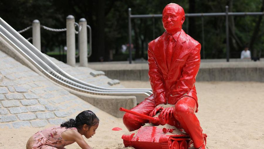 Children put sand on a statue of Russian President Vladimir Putin riding a tank created by French artist James Colomina in Central Park in Manhattan, New York City, U.S., August 2, 2022. REUTERS/Andrew Kelly