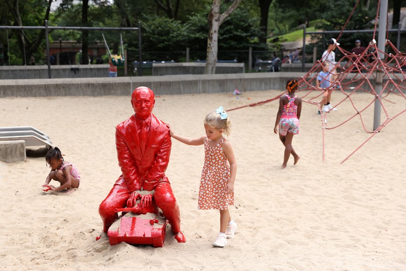 UKRAINE-CRISIS/USA-STATUE Children put sand on a statue of Russian President Vladimir Putin riding a tank created by French artist James Colomina in Central Park in Manhattan, New York City, U.S., August 2, 2022. REUTERS/Andrew Kelly