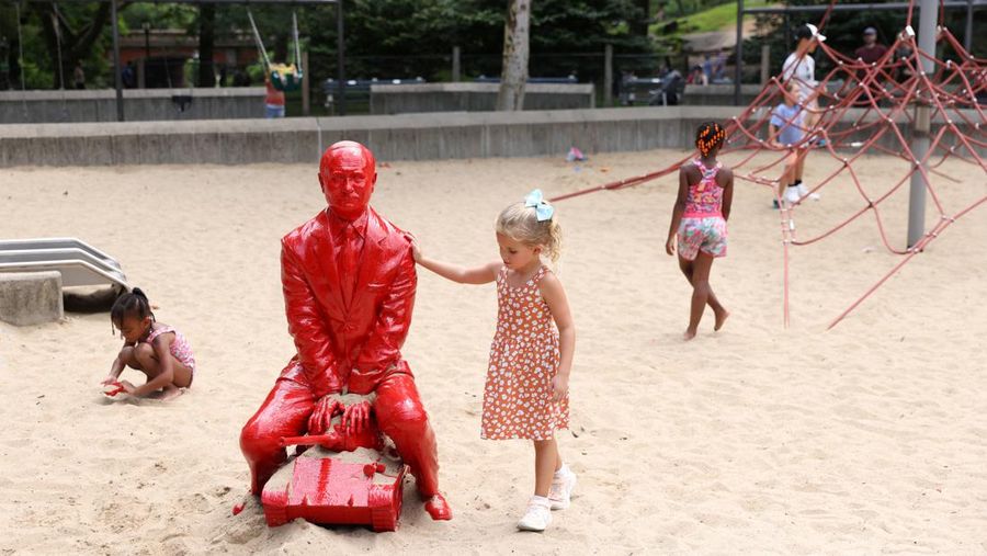 Children put sand on a statue of Russian President Vladimir Putin riding a tank created by French artist James Colomina in Central Park in Manhattan, New York City, U.S., August 2, 2022. REUTERS/Andrew Kelly