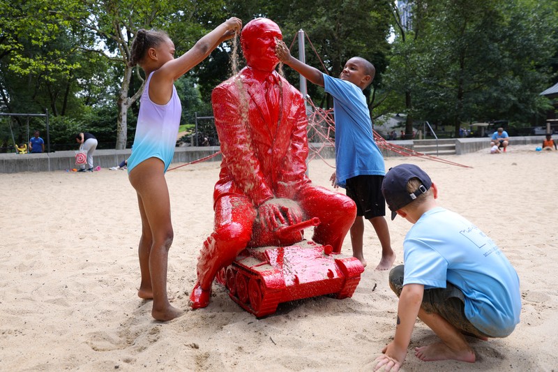 UKRAINE-CRISIS/USA-STATUE Children put sand on a statue of Russian President Vladimir Putin riding a tank created by French artist James Colomina in Central Park in Manhattan, New York City, U.S., August 2, 2022. REUTERS/Andrew Kelly