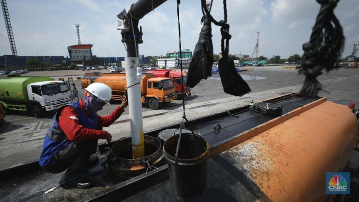 Pekerja berlumuran minyak kelapa sawit mentah atau Crude Palm Oil (CPO) dari Kalimantan saat bongkar muat di Kapal Kencana 89 di Pelabuhan Tanjung Priok, Jakarta. (CNBC Indonesia/Tri Susilo)