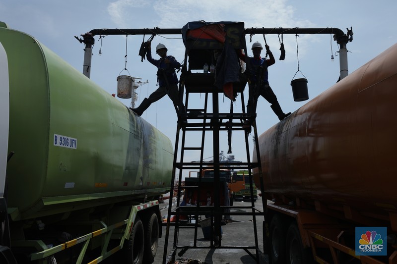 Pekerja berlumuran minyak kelapa sawit mentah atau Crude Palm Oil (CPO) dari Kalimantan saat bongkar muat di Kapal Kencana 89 di Pelabuhan Tanjung Priok, Jakarta. (CNBC Indonesia/Tri Susilo)