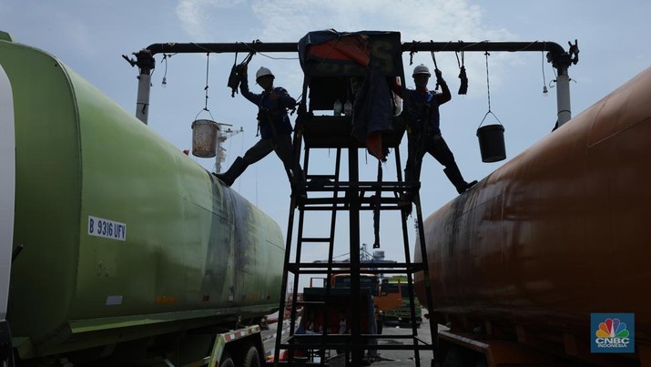 Pekerja berlumuran minyak kelapa sawit mentah atau Crude Palm Oil (CPO) dari Kalimantan saat bongkar muat di Kapal Kencana 89 di Pelabuhan Tanjung Priok, Jakarta. (CNBC Indonesia/Tri Susilo)