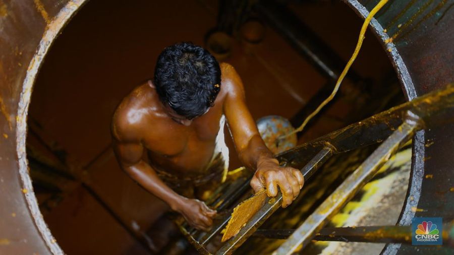 Pekerja berlumuran minyak kelapa sawit mentah atau Crude Palm Oil (CPO) dari Kalimantan saat bongkar muat di Kapal Kencana 89 di Pelabuhan Tanjung Priok, Jakarta. (CNBC Indonesia/Tri Susilo)