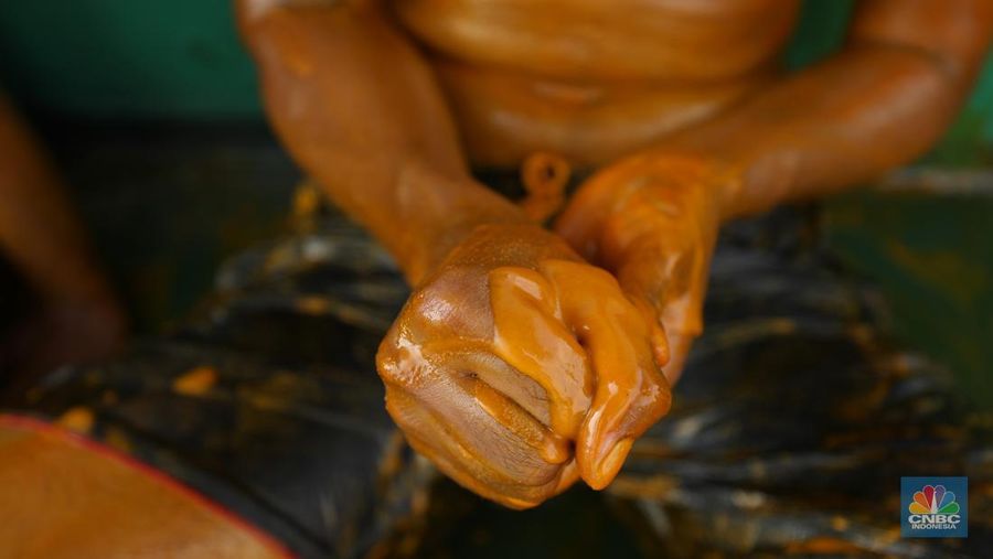 Pekerja berlumuran minyak kelapa sawit mentah atau Crude Palm Oil (CPO) dari Kalimantan saat bongkar muat di Kapal Kencana 89 di Pelabuhan Tanjung Priok, Jakarta. (CNBC Indonesia/Tri Susilo)