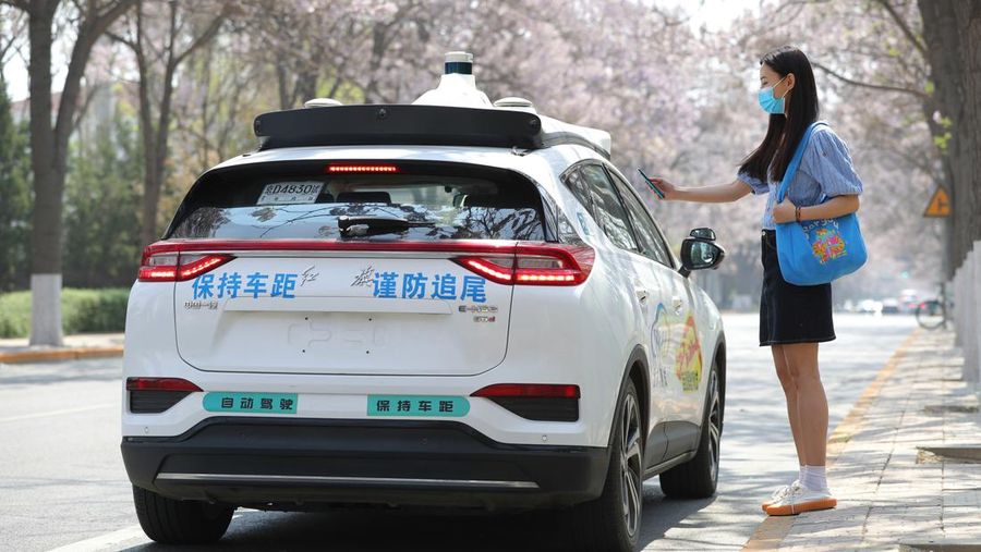 Penumpang memindai kode untuk menggunakan taksi robot Apollo Go buatan Baidu