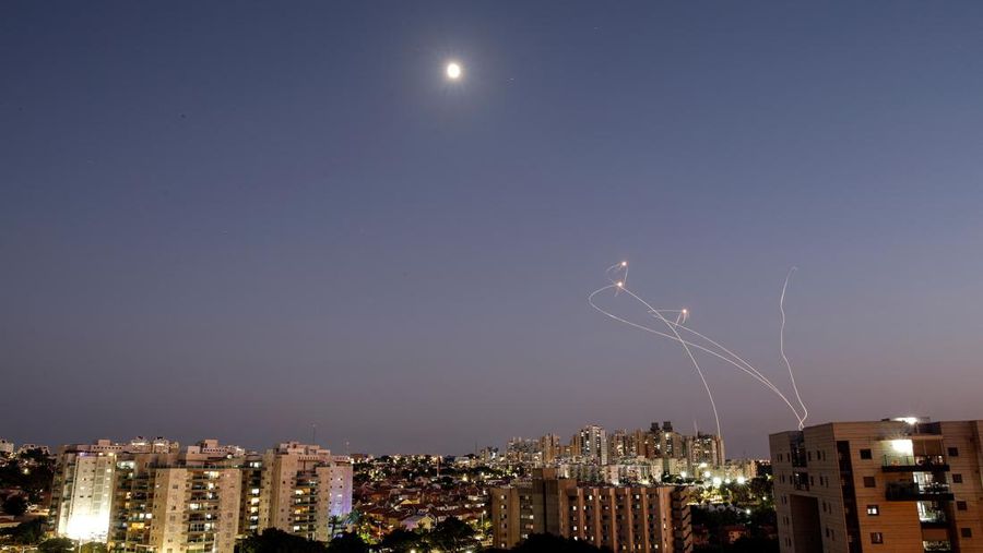 Garis-garis cahaya terlihat saat sistem anti-rudal Iron Dome Israel mencegat roket yang diluncurkan dari Jalur Gaza menuju Israel, seperti yang terlihat dari Ashkelon, Israel, Minggu (7/8/2022). (REUTERS/Amir Cohen)