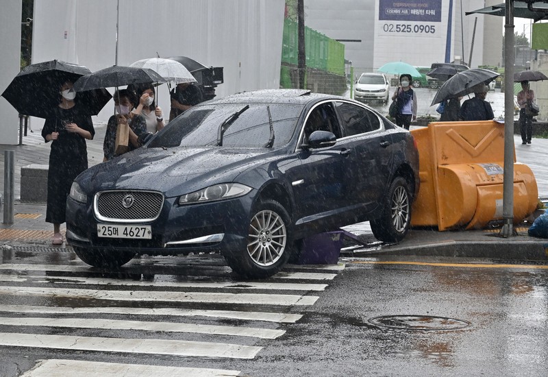 Mobil terendam banjir saat hujan deras di distrik Gangnam, Seoul, Korea Selatan, Senin (8/8/2022). (Photo by YONHAP / AFP)