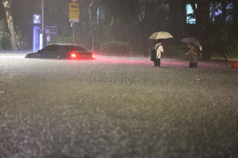 Mobil terendam banjir saat hujan deras di distrik Gangnam, Seoul, Korea Selatan, Senin (8/8/2022). (Photo by YONHAP / AFP)