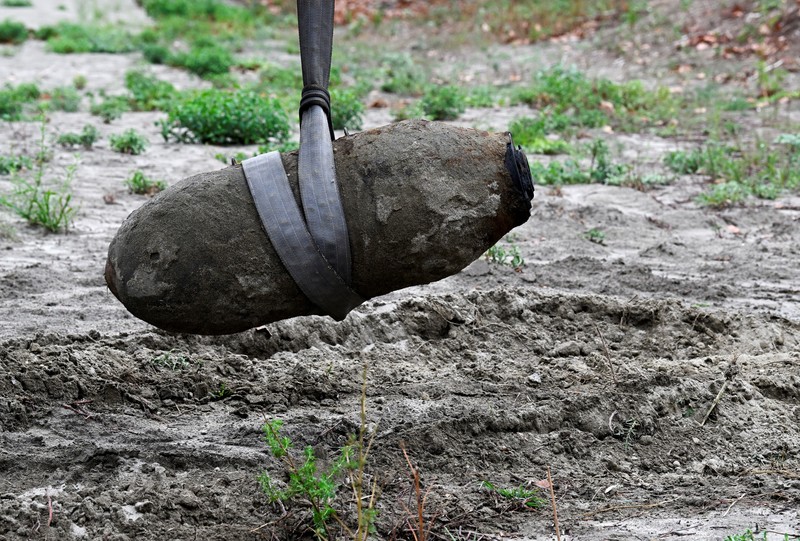 Anggota tentara Italis mengeluarkan bom Perang Dunia Kedua yang ditemukan di Sungai Po yang mengering di Borgo Virgilio, Italia, Minggu (7/8/2022). (REUTERS/Flavio Lo Scalzo)