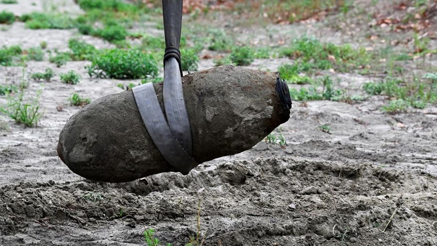 Anggota tentara Italis mengeluarkan bom Perang Dunia Kedua yang ditemukan di Sungai Po yang mengering di Borgo Virgilio, Italia, Minggu (7/8/2022). (REUTERS/Flavio Lo Scalzo)