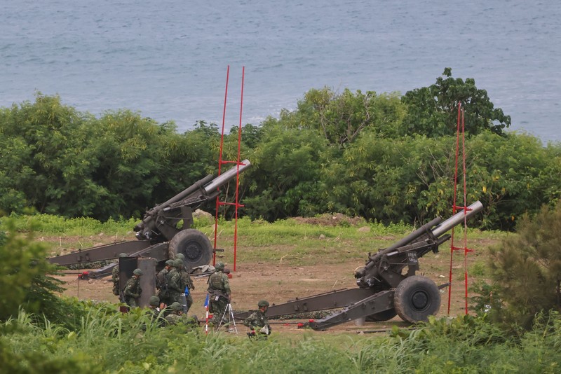 Tentara menembakkan howitzer 155mm selama latihan militer tahunan di daerah Pingtung, Taiwan selatan, Selasa (9/8/2022). (REUTERS/Ann Wang)