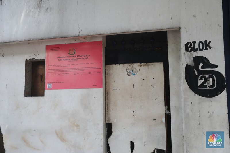 Penyitaan aset Surya Darmadi di Gedung Palma One Pekerja melintas di depan papan bertuliskan sitaan aset Surya Darmadi di Gedung Palma One, Jakarta, Selasa (9/8/2022). Kejaksaan Agung telah menyita sebanyak 23 aset milik PT Duta Palma Group terkait tersangka kasus korupsi Rp 78 triliun, Surya Darmadi. (CNBC Indonesia/ Muhammad Sabki)