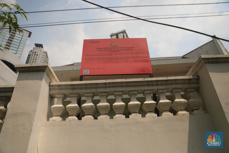Pekerja melintas di depan papan bertuliskan sitaan aset Surya Darmadi di Gedung Palma One, Jakarta, Selasa (9/8/2022). Kejaksaan Agung telah menyita sebanyak 23 aset milik PT Duta Palma Group terkait tersangka kasus korupsi Rp 78 triliun, Surya Darmadi. (CNBC Indonesia/ Muhammad Sabki)