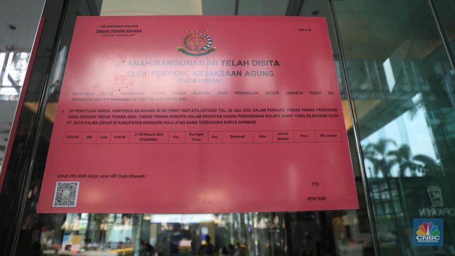 Pekerja melintas di depan papan bertuliskan sitaan aset Surya Darmadi di Gedung Palma One, Jakarta, Selasa (9/8/2022). Kejaksaan Agung telah menyita sebanyak 23 aset milik PT Duta Palma Group terkait tersangka kasus korupsi Rp 78 triliun, Surya Darmadi. (CNBC Indonesia/ Muhammad Sabki)