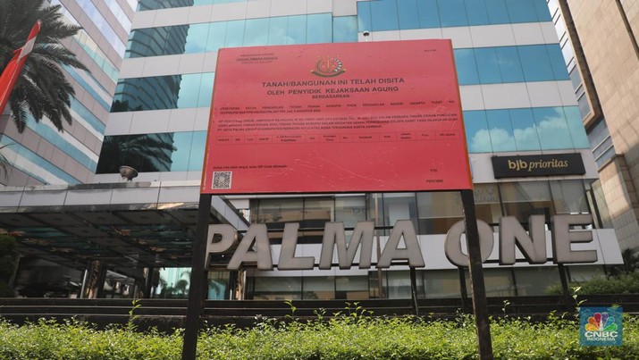 Penyitaan aset Surya Darmadi di Gedung Palma One Pekerja melintas di depan papan bertuliskan sitaan aset Surya Darmadi di Gedung Palma One, Jakarta, Selasa (9/8/2022). Kejaksaan Agung telah menyita sebanyak 23 aset milik PT Duta Palma Group terkait tersangka kasus korupsi Rp 78 triliun, Surya Darmadi. (CNBC Indonesia/ Muhammad Sabki)
