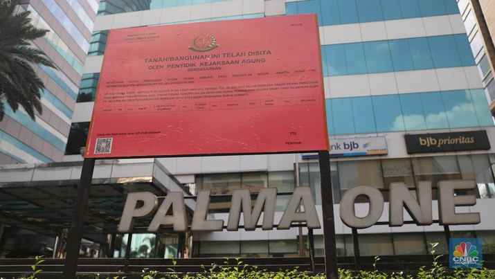 Penyitaan aset Surya Darmadi di Gedung Palma One Pekerja melintas di depan papan bertuliskan sitaan aset Surya Darmadi di Gedung Palma One, Jakarta, Selasa (9/8/2022). Kejaksaan Agung telah menyita sebanyak 23 aset milik PT Duta Palma Group terkait tersangka kasus korupsi Rp 78 triliun, Surya Darmadi. (CNBC Indonesia/ Muhammad Sabki)