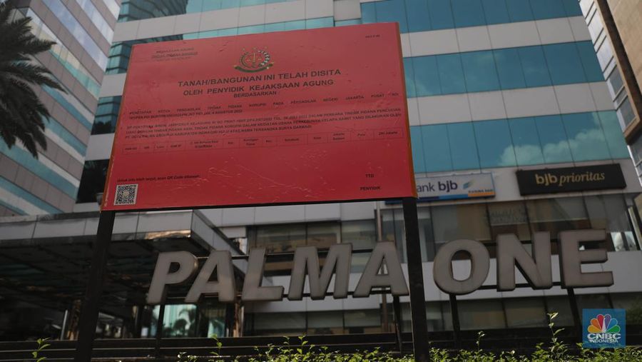 Pekerja melintas di depan papan bertuliskan sitaan aset Surya Darmadi di Gedung Palma One, Jakarta, Selasa (9/8/2022). Kejaksaan Agung telah menyita sebanyak 23 aset milik PT Duta Palma Group terkait tersangka kasus korupsi Rp 78 triliun, Surya Darmadi. (CNBC Indonesia/ Muhammad Sabki)