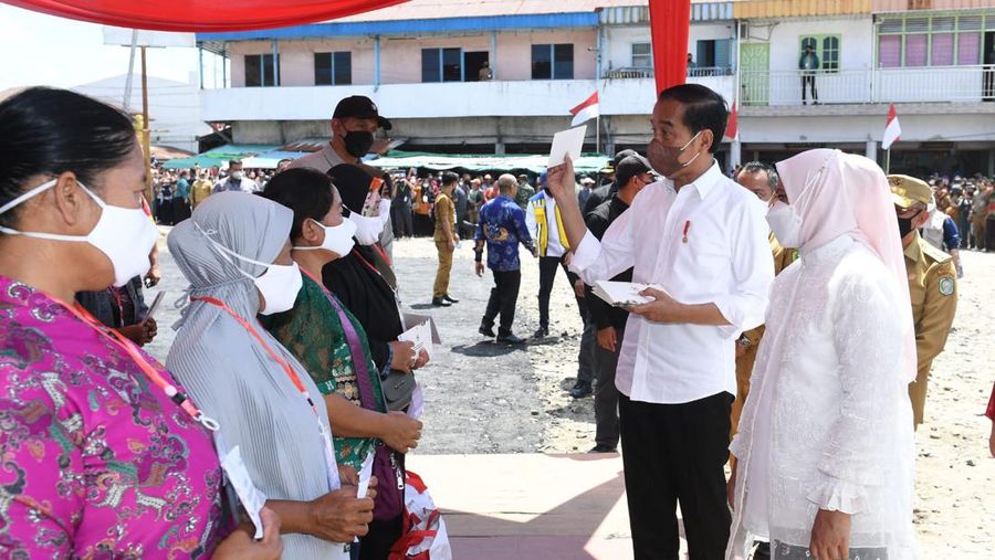 Presiden Joko Widodo didampingi Ibu Iriana Joko Widodo menyerahkan Bantuan Modal Kerja (BMK) dan Bantuan Langsung Tunai (BLT) minyak goreng kepada peserta Program Keluarga Harapan (PKH) di Pasar Sungai Duri, Kabupaten Bengkayang, Provinsi Kalimantan Barat, pada Selasa, (9/8/2022). (Foto: Kris - Biro Pers Sekretariat Presiden)