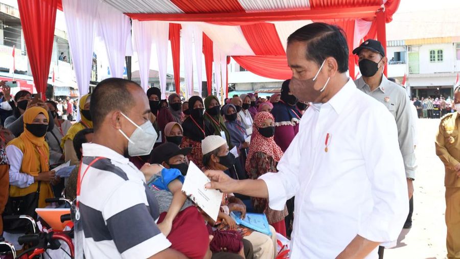Presiden Joko Widodo didampingi Ibu Iriana Joko Widodo menyerahkan Bantuan Modal Kerja (BMK) dan Bantuan Langsung Tunai (BLT) minyak goreng kepada peserta Program Keluarga Harapan (PKH) di Pasar Sungai Duri, Kabupaten Bengkayang, Provinsi Kalimantan Barat, pada Selasa, (9/8/2022). (Foto: Kris - Biro Pers Sekretariat Presiden)