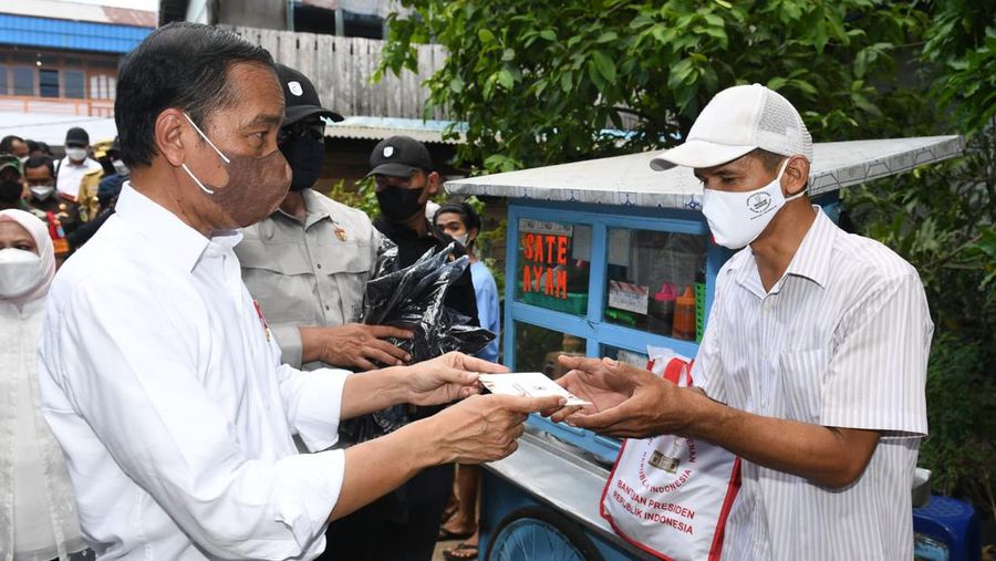 Presiden Joko Widodo didampingi Ibu Iriana Joko Widodo menyerahkan Bantuan Modal Kerja (BMK) dan Bantuan Langsung Tunai (BLT) minyak goreng kepada peserta Program Keluarga Harapan (PKH) di Pasar Sungai Duri, Kabupaten Bengkayang, Provinsi Kalimantan Barat, pada Selasa, (9/8/2022). (Foto: Kris - Biro Pers Sekretariat Presiden)