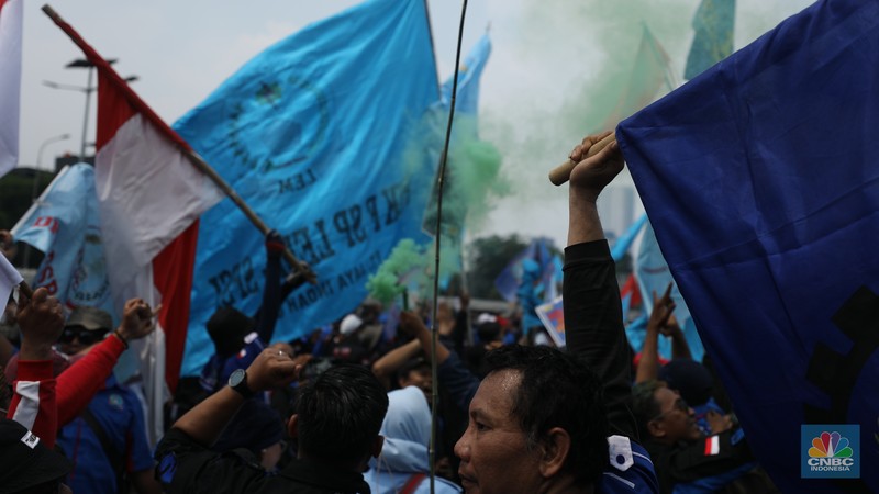 Sejumlah massa buruh melakukan aski di depan gedung DPR/MPR, Jakarta, Rabu (10/8/022). Dalam aksinya mereka mengibarkan bendera serta membentangkan atribut seperti poster dan spanduk bertulisan tuntutan pencabutan Undang-Undang Cipta Kerja. (CNBC Indonesia/ Tr5i Susilo)