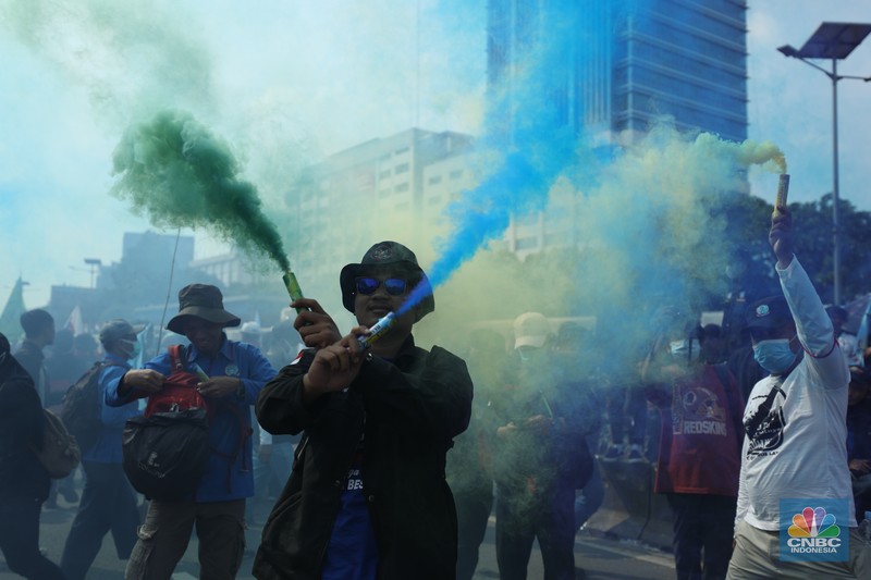 Sejumlah massa buruh melakukan aski di depan gedung DPR/MPR, Jakarta, Rabu (10/8/022). Dalam aksinya mereka mengibarkan bendera serta membentangkan atribut seperti poster dan spanduk bertulisan tuntutan pencabutan Undang-Undang Cipta Kerja. (CNBC Indonesia/ Tri Susilo)