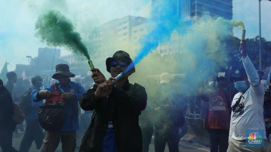 Sejumlah massa buruh melakukan aski di depan gedung DPR/MPR, Jakarta, Rabu (10/8/022). Dalam aksinya mereka mengibarkan bendera serta membentangkan atribut seperti poster dan spanduk bertulisan tuntutan pencabutan Undang-Undang Cipta Kerja. (CNBC Indonesia/ Tri Susilo)