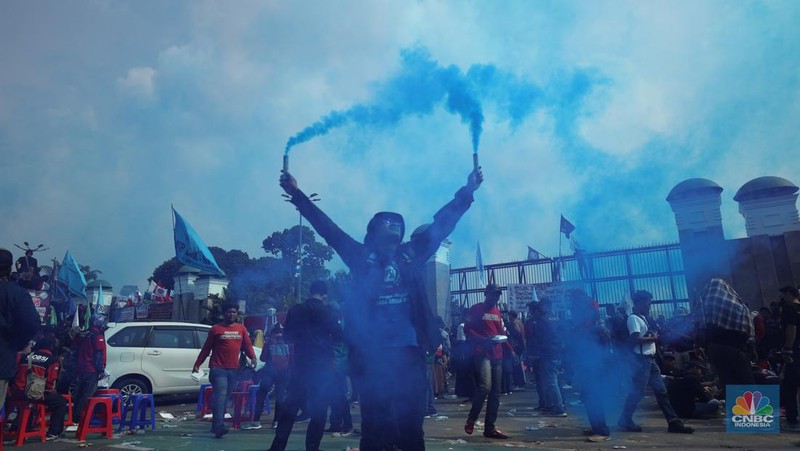 Sejumlah massa buruh melakukan aski di depan gedung DPR/MPR, Jakarta, Rabu (10/8/022). Dalam aksinya mereka mengibarkan bendera serta membentangkan atribut seperti poster dan spanduk bertulisan tuntutan pencabutan Undang-Undang Cipta Kerja. (CNBC Indonesia/ Tri Susilo)