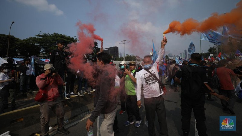 Sejumlah massa buruh melakukan aski di depan gedung DPR/MPR, Jakarta, Rabu (10/8/022). Dalam aksinya mereka mengibarkan bendera serta membentangkan atribut seperti poster dan spanduk bertulisan tuntutan pencabutan Undang-Undang Cipta Kerja. (CNBC Indonesia/ Tri Susilo)