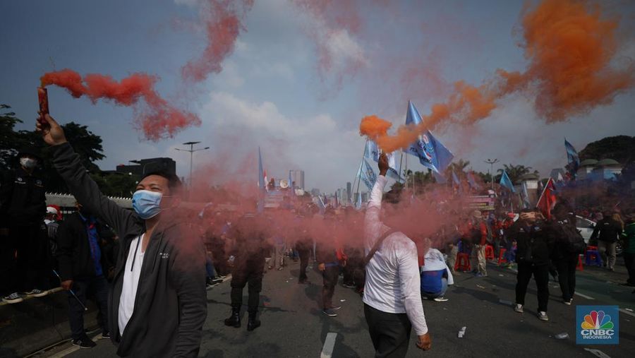 Sejumlah massa buruh melakukan aski di depan gedung DPR/MPR, Jakarta, Rabu (10/8/022). Dalam aksinya mereka mengibarkan bendera serta membentangkan atribut seperti poster dan spanduk bertulisan tuntutan pencabutan Undang-Undang Cipta Kerja. (CNBC Indonesia/ Tri Susilo)