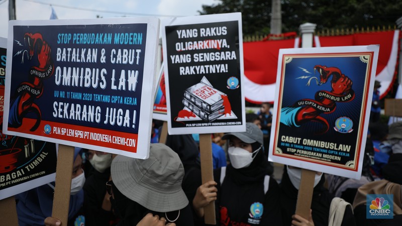 Sejumlah massa buruh melakukan aski di depan gedung DPR/MPR, Jakarta, Rabu (10/8/022). Dalam aksinya mereka mengibarkan bendera serta membentangkan atribut seperti poster dan spanduk bertulisan tuntutan pencabutan Undang-Undang Cipta Kerja. (CNBC Indonesia/ Tr5i Susilo)