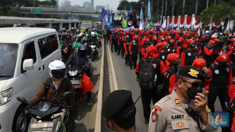 Sejumlah massa buruh melakukan aski di depan gedung DPR/MPR, Jakarta, Rabu (10/8/022). Dalam aksinya mereka mengibarkan bendera serta membentangkan atribut seperti poster dan spanduk bertulisan tuntutan pencabutan Undang-Undang Cipta Kerja. (CNBC Indonesia/ Tr5i Susilo)