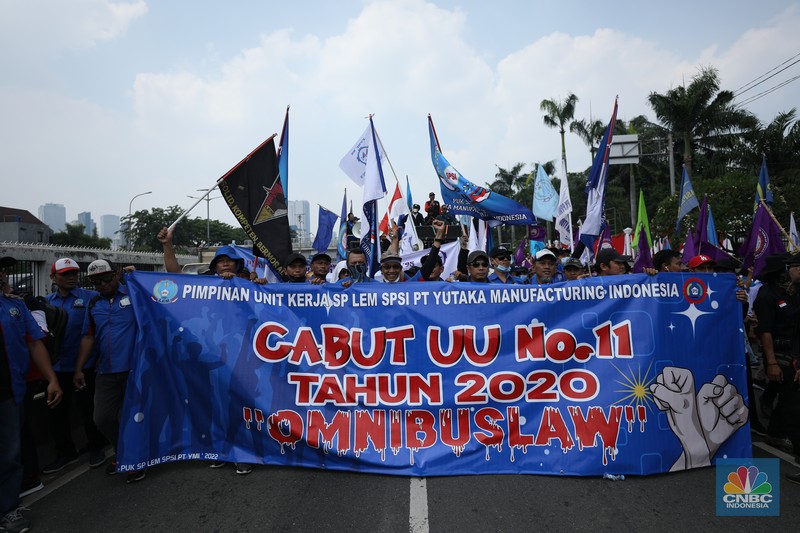 Sejumlah massa buruh melakukan aski di depan gedung DPR/MPR, Jakarta, Rabu (10/8/022). Dalam aksinya mereka mengibarkan bendera serta membentangkan atribut seperti poster dan spanduk bertulisan tuntutan pencabutan Undang-Undang Cipta Kerja. (CNBC Indonesia/ Tr5i Susilo)