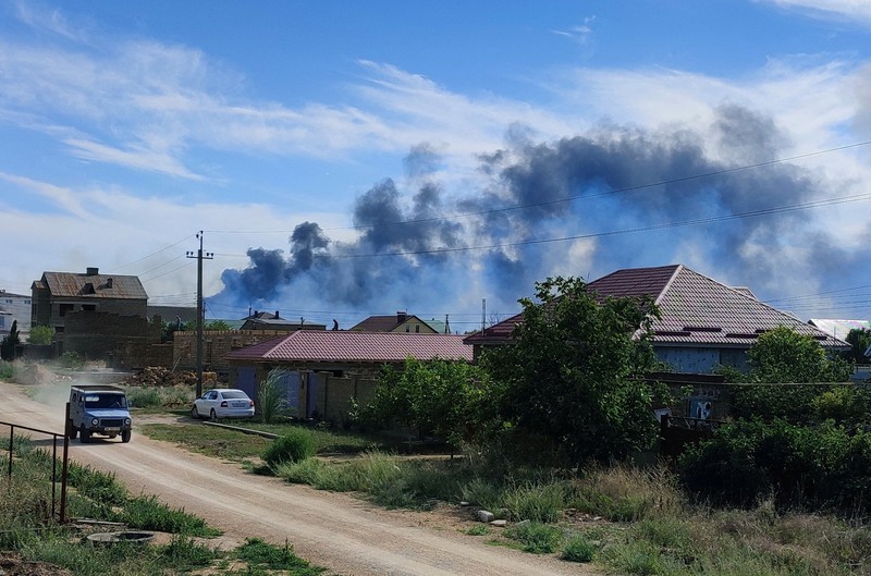 Asap mengepul setelah ledakan terdengar dari arah pangkalan udara militer Rusia di dekat Novofedorivka, Crimea, Selasa (9/8/2022). (Pool via Reuters)