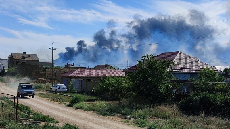 Asap mengepul setelah ledakan terdengar dari arah pangkalan udara militer Rusia di dekat Novofedorivka, Crimea, Selasa (9/8/2022). (Pool via Reuters)