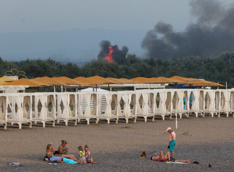 Asap mengepul setelah ledakan terdengar dari arah pangkalan udara militer Rusia di dekat Novofedorivka, Crimea, Selasa (9/8/2022). (Pool via Reuters)