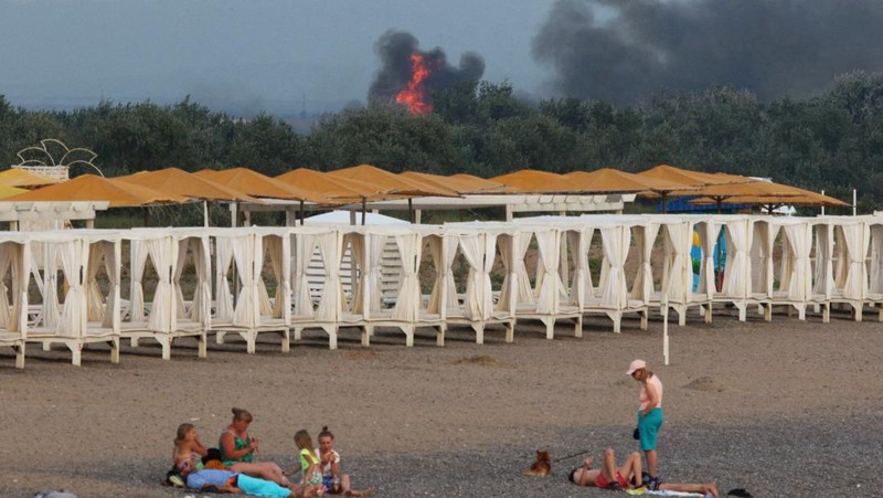 Asap mengepul setelah ledakan terdengar dari arah pangkalan udara militer Rusia di dekat Novofedorivka, Crimea, Selasa (9/8/2022). (Pool via Reuters)