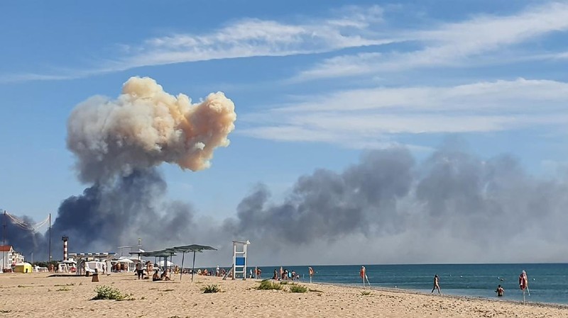 Asap mengepul setelah ledakan terdengar dari arah pangkalan udara militer Rusia di dekat Novofedorivka, Crimea, Selasa (9/8/2022). (Pool via Reuters)