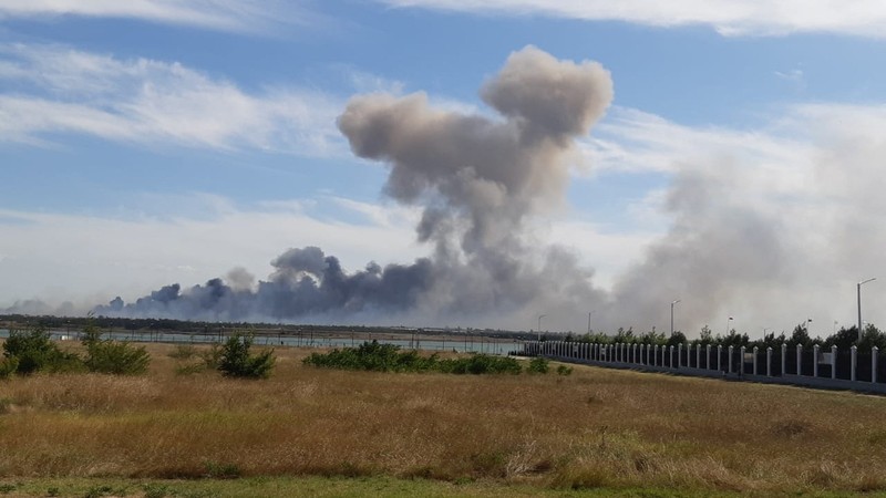 Asap mengepul setelah ledakan terdengar dari arah pangkalan udara militer Rusia di dekat Novofedorivka, Crimea, Selasa (9/8/2022). (Pool via Reuters)