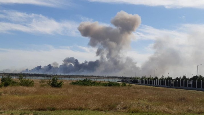 Asap mengepul setelah ledakan terdengar dari arah pangkalan udara militer Rusia di dekat Novofedorivka, Crimea, Selasa (9/8/2022). (Pool via Reuters)