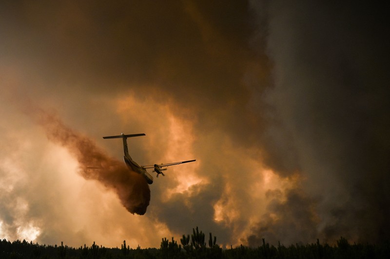 Petugas pemadam kebakaran berupaya memadamkan api di Belin-Beliet, saat kebakaran hutan terus meluas di wilayah Gironde, Prancis barat daya,Rabu (10/8/2022). (REUTERS/Stephane Mahe)