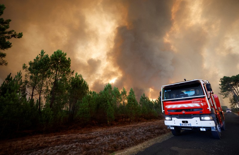 Petugas pemadam kebakaran berupaya memadamkan api di Belin-Beliet, saat kebakaran hutan terus meluas di wilayah Gironde, Prancis barat daya,Rabu (10/8/2022). (REUTERS/Stephane Mahe)