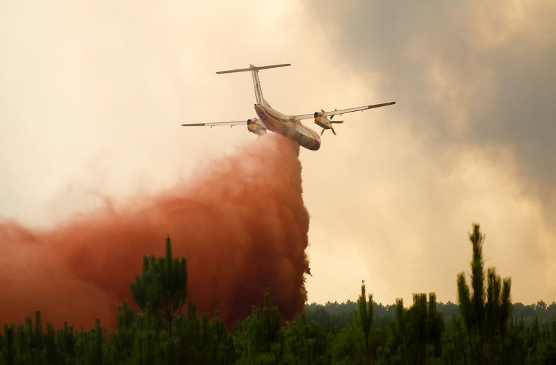 Petugas pemadam kebakaran berupaya memadamkan api di Belin-Beliet, saat kebakaran hutan terus meluas di wilayah Gironde, Prancis barat daya,Rabu (10/8/2022). (REUTERS/Stephane Mahe)